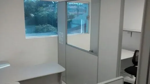 Sala do escritório da Marcos Welber SEO, com mesa, divisória de vidro e janela